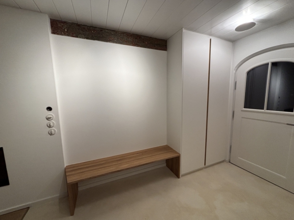 Garderobe nach Maß mit Eiche-Sitzbank Flur mit weiß lackiertem Einbauschrank, Griffmulde aus Eiche und langer Sitzbank aus Massivholz