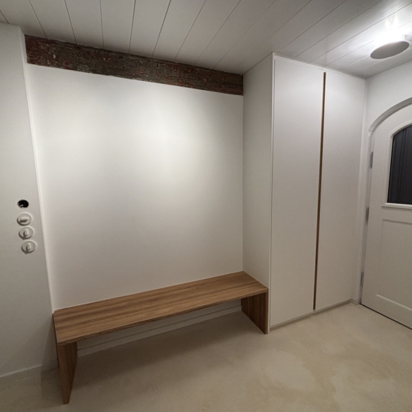 Flur mit weiß lackiertem Einbauschrank, Griffmulde aus Eiche und langer Sitzbank aus Massivholz