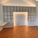 Weißes Einbauregal mit Schreibtisch und geschlossener Schiebetür mit umlaufender warmer LED-Beleuchtung