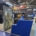 Individueller Messestand mit lackierter blauer Empfangstheke, beleuchteter Vitrine und Präsentationsflächen