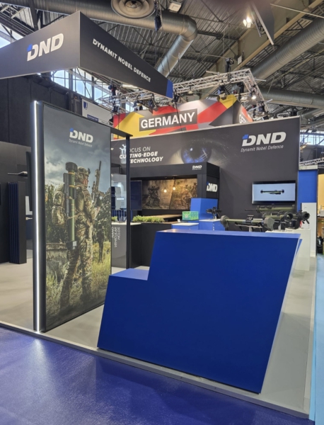 Individuelle Messemöbel – beleuchtete Vitrine und Empfangstheke Individueller Messestand mit lackierter blauer Empfangstheke, beleuchteter Vitrine und Präsentationsflächen