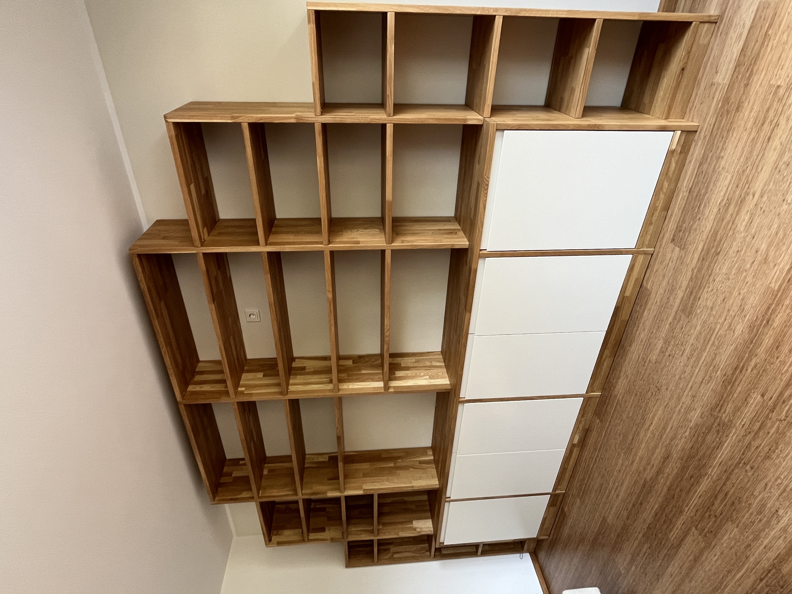 Maßgefertigte Regalwand aus Eiche mit weißen Unterschränken in Bonn