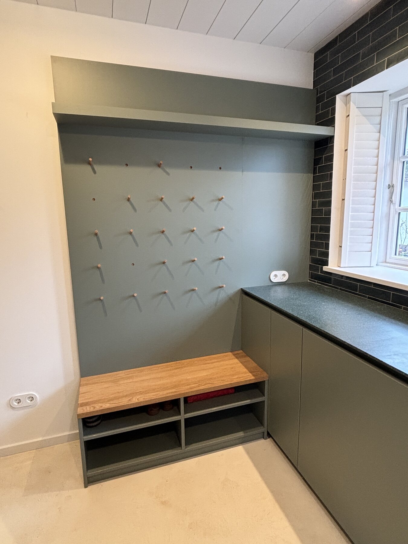 Sitzbank mit Schuhablage und Wandgarderobe im Hauswirtschaftsraum